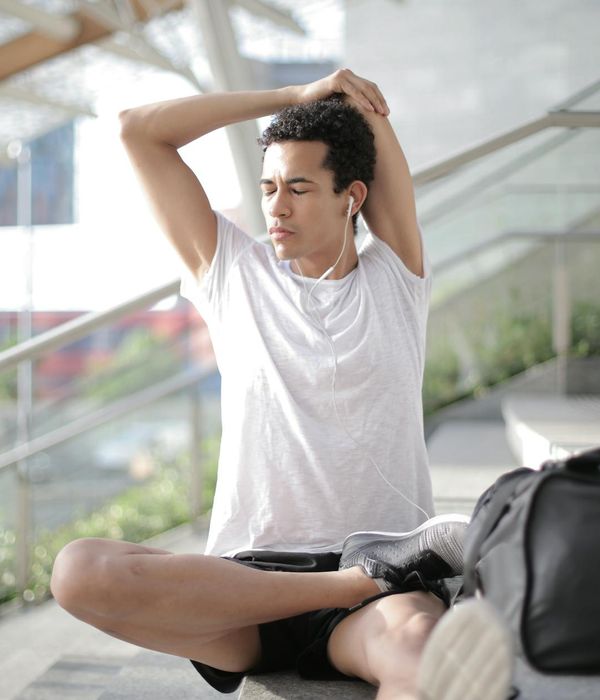 Man stretching in a calm, focused environment with soft lighting.